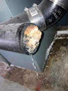 A drain pipe cut open showing the blockage inside
