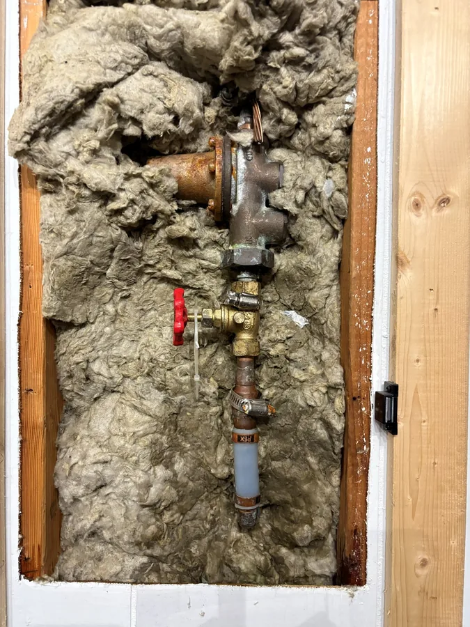 Before: The old main shutoff valve in the open wall