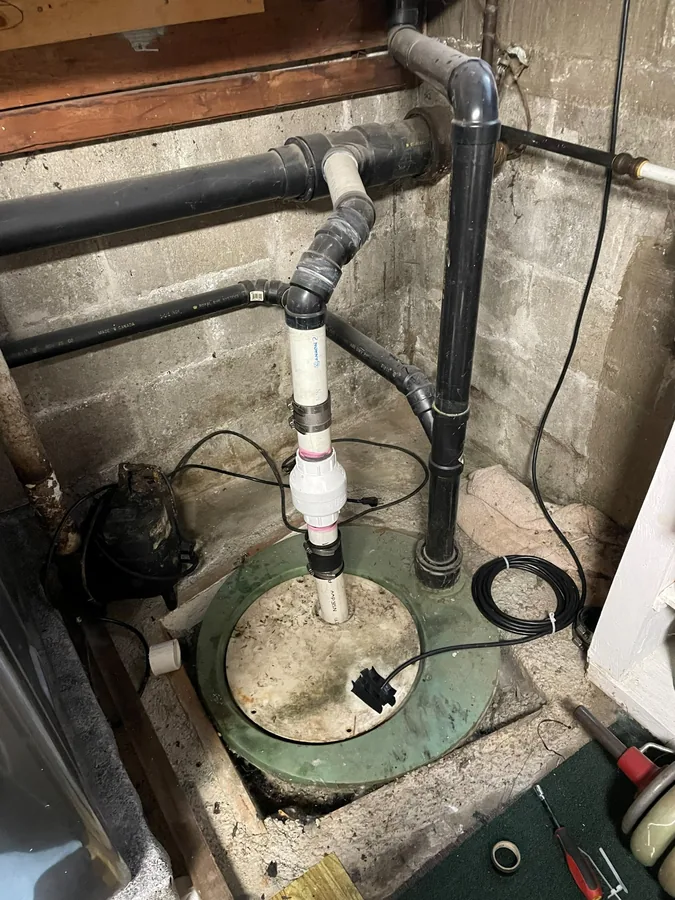 Before: The old sump pump and its pipework in the pit